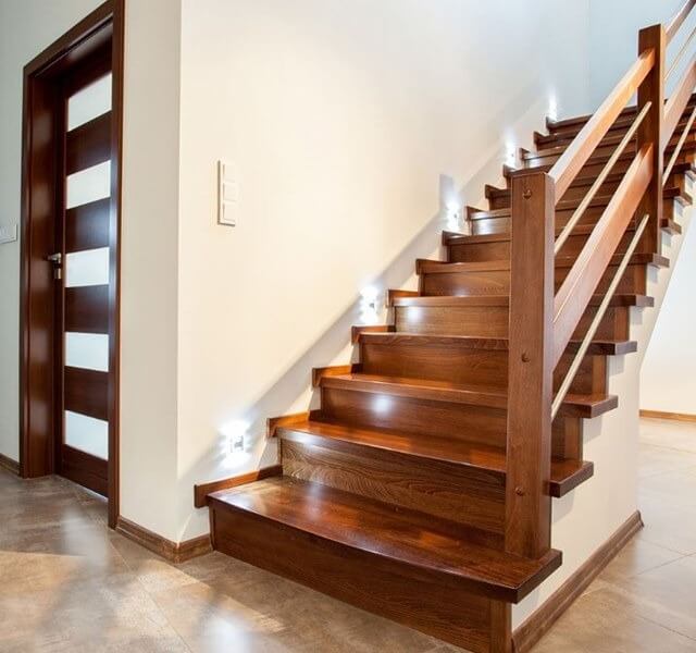 Cầu thang gỗ hiện đại với đèn LED chiếu sáng, tạo không gian nội thất sang trọng và ấm cúng trong ngôi nhà.