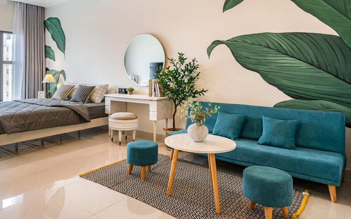 Phòng khách hiện đại với sofa xanh, bàn tròn và cây trang trí nội thất.