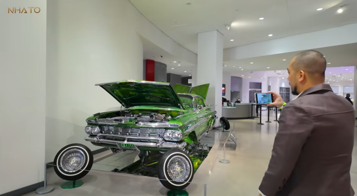 che-xanh Người đàn ông chụp xe ô tô cổ điển màu xanh lá cây trưng bày trong bảo tàng xe hơi hiện đại.