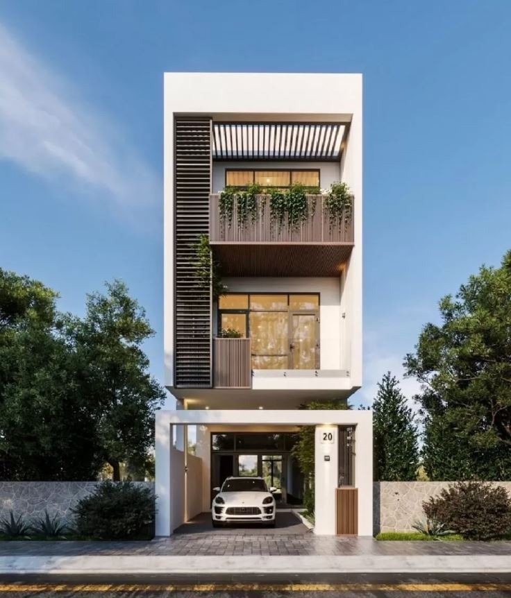 Nhà phố hiện đại 3 tầng, mặt tiền có ban công xanh và gara ô tô, nằm giữa hai hàng cây xanh tươi.