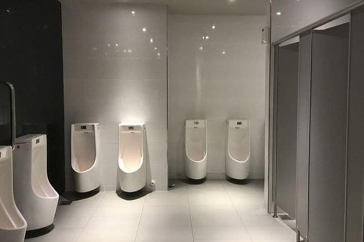 chon-bon-tieu-nam-cho-dien-tich-nhu-the-nao Phòng vệ sinh nam hiện đại với nhiều bồn tiểu trắng, thiết kế sạch sẽ và sang trọng.
