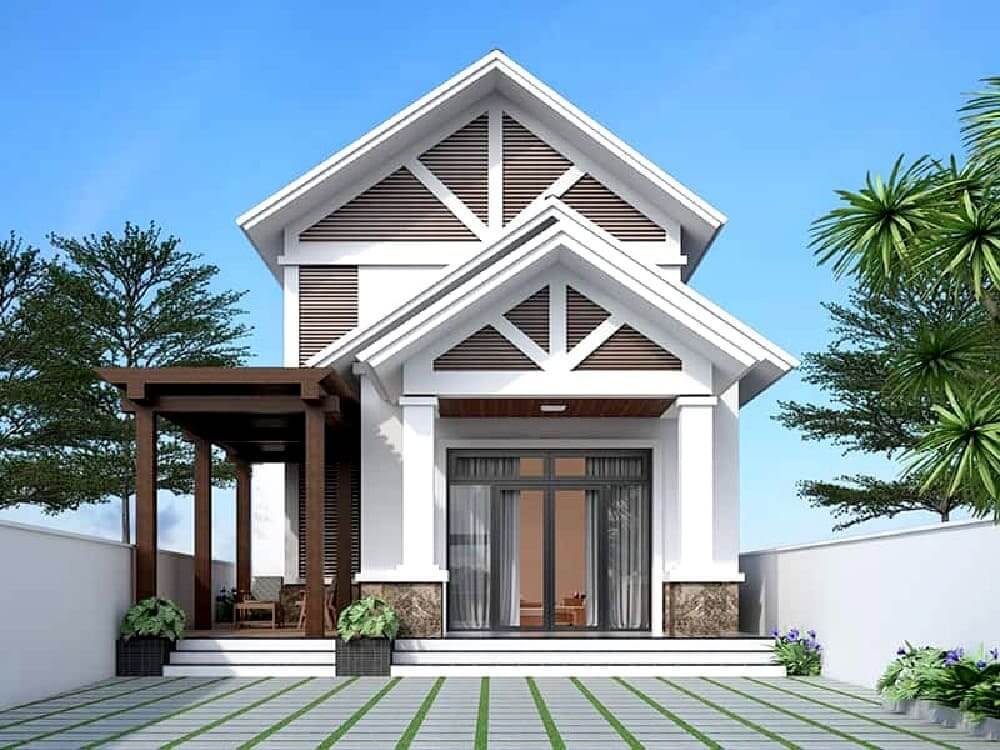 Nhà mái thái màu trắng hiện đại với sân lát gạch, cây cối xanh tươi xung quanh, trời xanh trong.