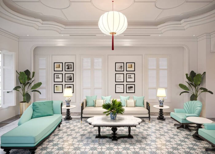 Phòng khách sang trọng với ghế sofa xanh, tranh treo tường, đèn trần và cây cảnh.