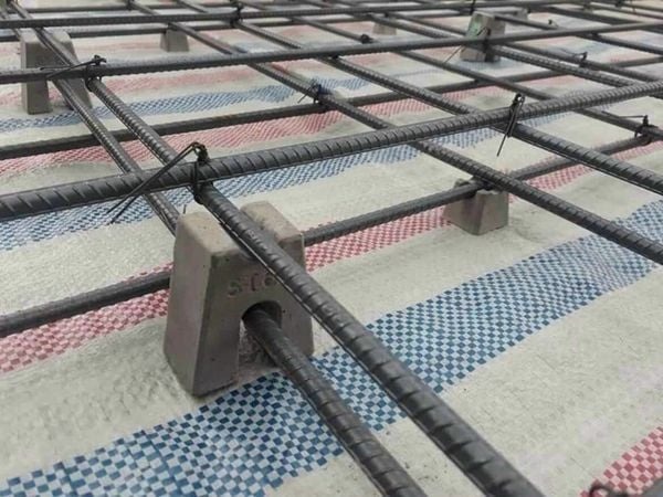 Giàn cốt thép trần nhà với thanh đỡ chắc chắn trên lớp vải, chuẩn bị cho công trình xây dựng.