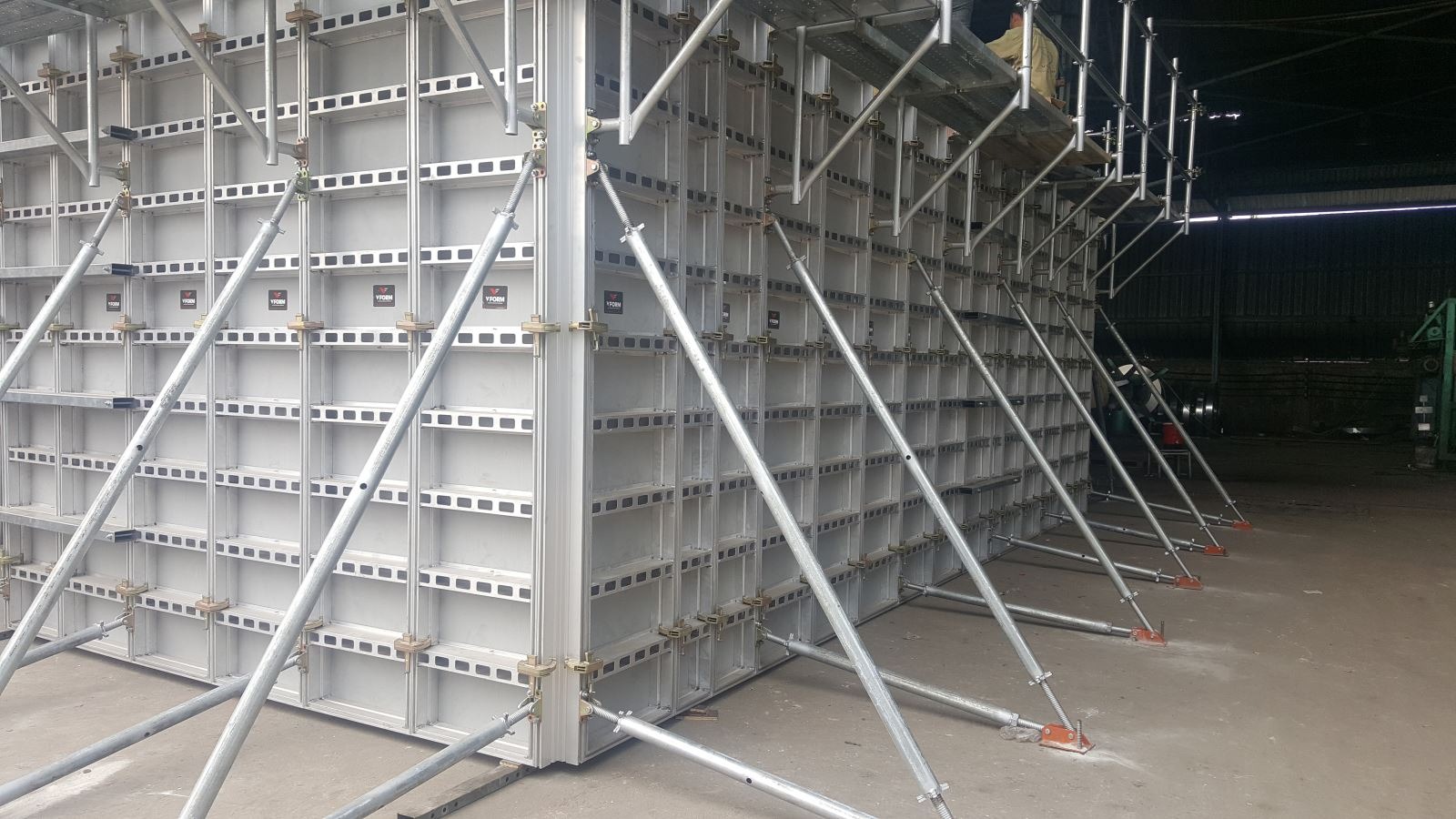 cop-pha-composite Giàn giáo cốp pha công nghiệp trong nhà xưởng xây dựng với các thanh chống kim loại.