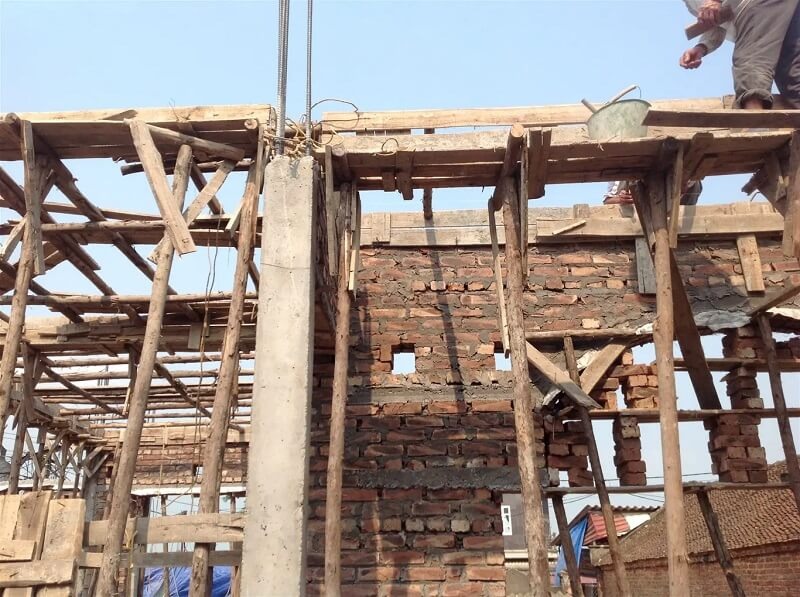cop-pha-go Công trình xây dựng với khung gỗ và tường gạch đang được thi công vào ban ngày.