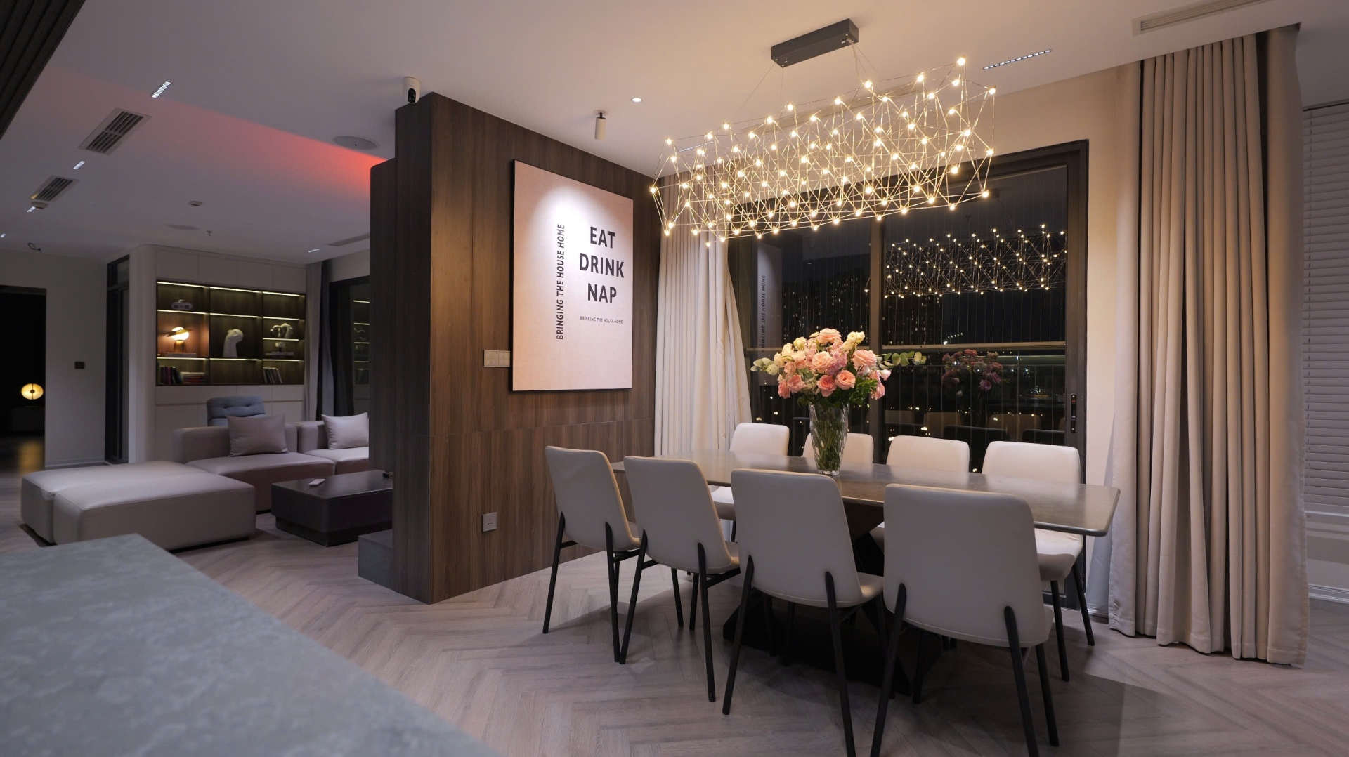 cp32g5a97xv4ouendk01 Phòng ăn sang trọng với đèn chùm hiện đại, bàn dài và hoa tươi tạo điểm nhấn.