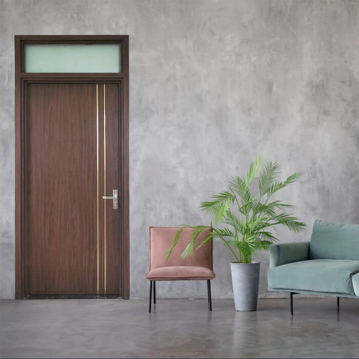 cua-phong-ngu-nhua-composite Cửa gỗ màu nâu cạnh ghế hồng, ghế xanh và cây kiểng trong phòng khách tối giản.