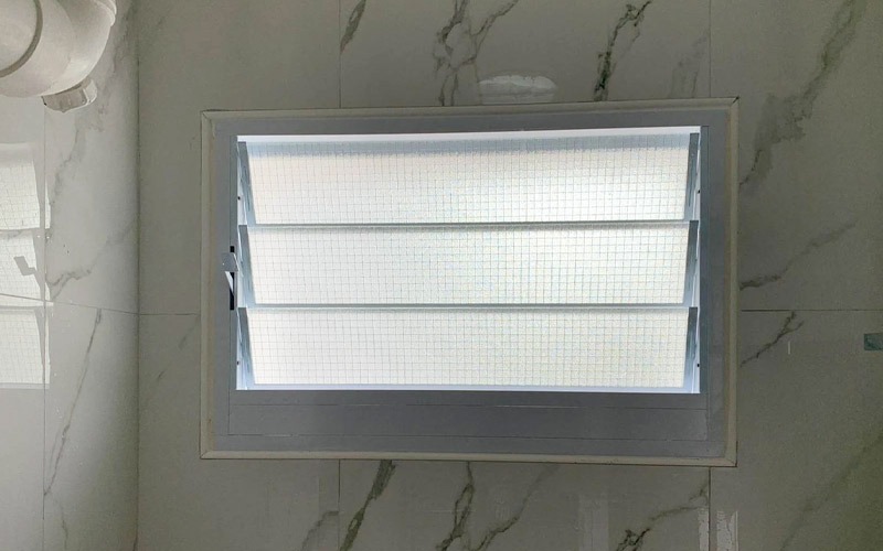 Cửa sổ kính cường lực với ánh sáng tự nhiên, thiết kế tối giản phù hợp cho phòng tắm hiện đại.