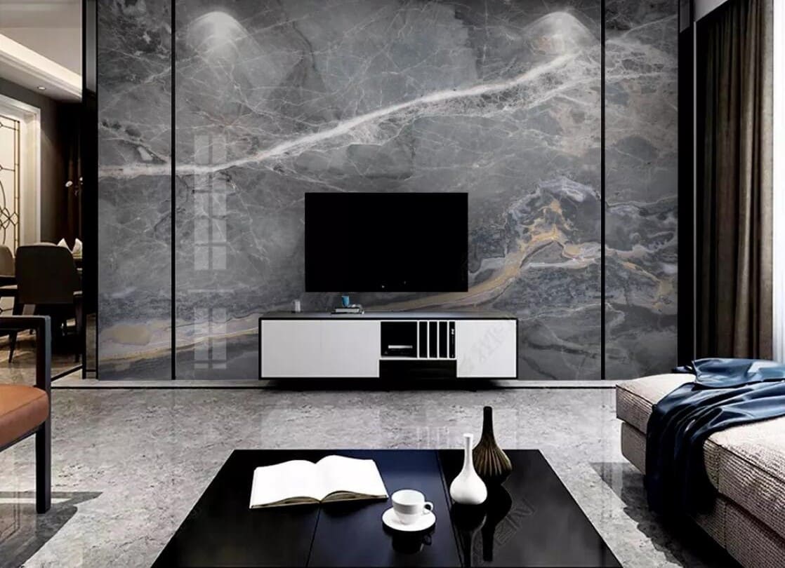 Phòng khách hiện đại với tường đá marble, tivi, sofa và bàn trà đen trang trí sách, cốc và bình hoa.