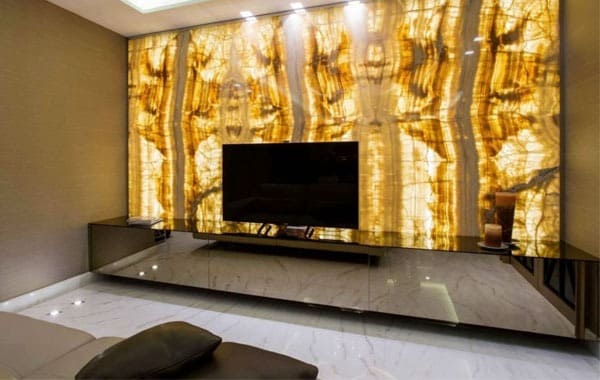 Phòng khách hiện đại với vách đá cẩm thạch phát sáng và TV màn hình phẳng, tạo không gian sang trọng và ấm cúng.