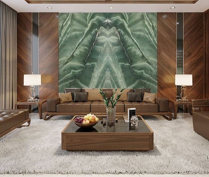 Phòng khách hiện đại với ghế sofa, bàn gỗ, tranh đá xanh lớn, thảm trải sàn trắng và đèn bàn.