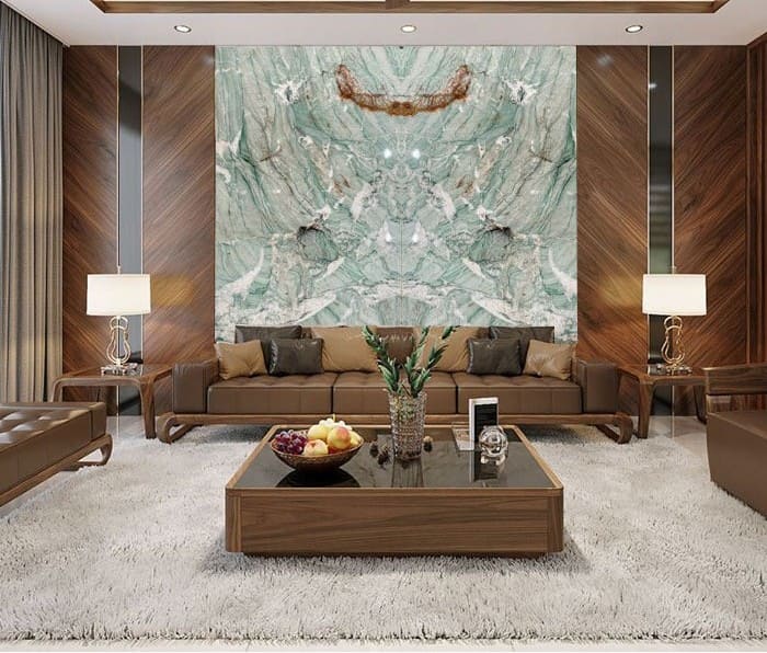 Phòng khách sang trọng với ghế sofa da, bàn trà hiện đại và bức tường đá cẩm thạch tinh tế.