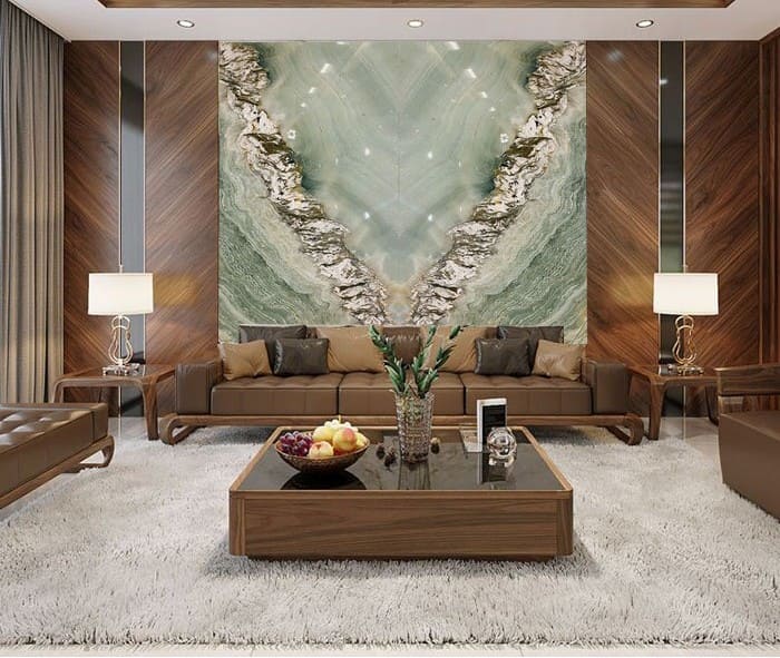 Phòng khách hiện đại với tường đá cẩm thạch, sofa da, bàn gỗ và thảm trắng sang trọng.