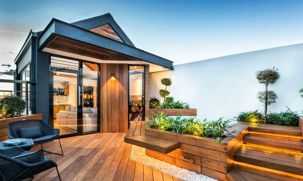 Sân thượng hiện đại với sàn gỗ, ghế ngoài trời và cây xanh tạo không gian thư giãn thoáng đãng.