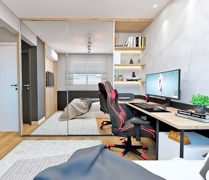 Phòng ngủ với góc chơi game, ghế game đỏ đen, màn hình máy tính lớn và giá sách trang trí hiện đại.