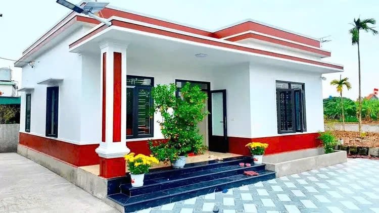 Ngôi nhà cấp 4 hiện đại với sân vườn, gam màu trắng đỏ, cây cảnh phía trước.