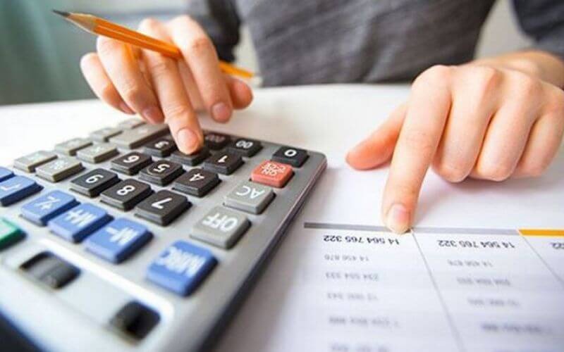 Người sử dụng máy tính và bảng tính để thực hiện tính toán tài chính và quản lý ngân sách trên văn phòng.