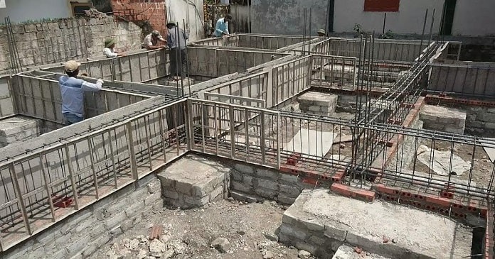 Công nhân xây dựng móng nhà với khung thép và gạch, chuẩn bị cho công trình xây dựng kiên cố và bền vững.