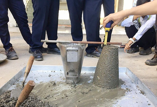 Đo độ sụt của bê tông bằng nón tiêu chuẩn tại công trường xây dựng.