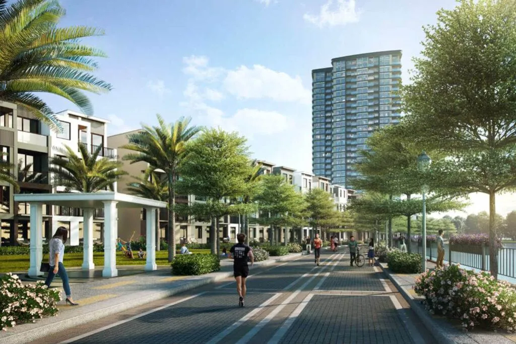 du-an-alta-heights-the-9-stellars-sonkim-land-6-1024x683-1 Đường dạo bộ bên sông với cây xanh và các tòa nhà hiện đại, trời nắng đẹp.