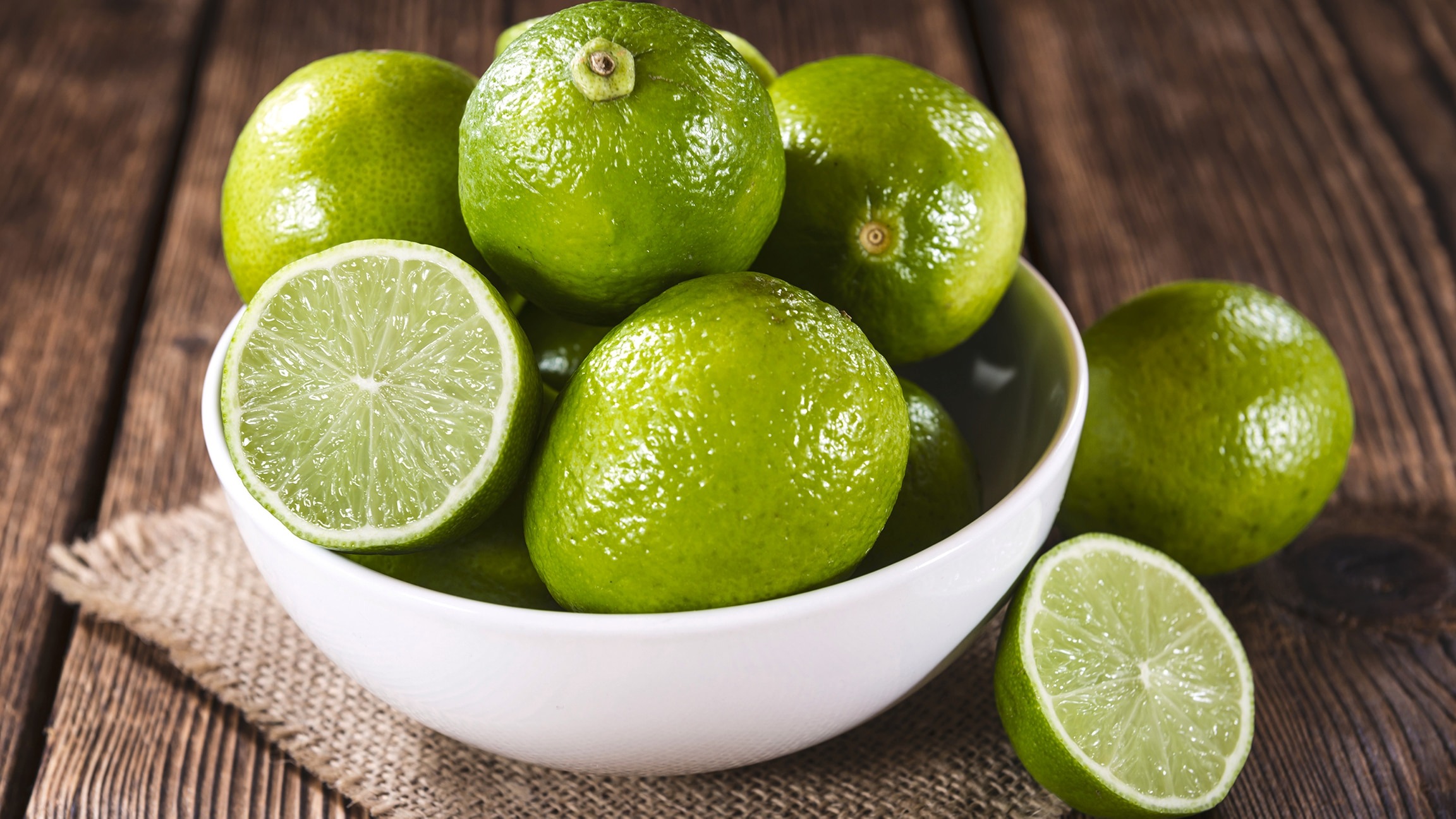 dung-chanh-tuoi Bát chanh tươi sáng đặt trên bàn gỗ nâu, một lát chanh được cắt đôi, thích hợp làm nguyên liệu ẩm thực.