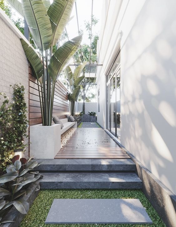 Lối đi nhỏ với cây xanh và ghế tựa bên trong không gian hiện đại và thoáng đãng.