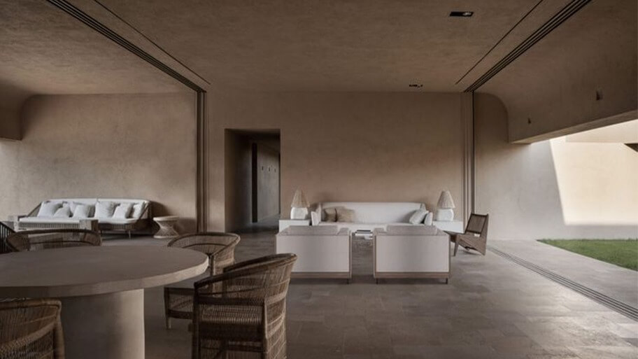 Phòng khách hiện đại với nội thất tối giản, ghế sofa trắng và bàn ăn tròn, không gian mở thoáng đãng.