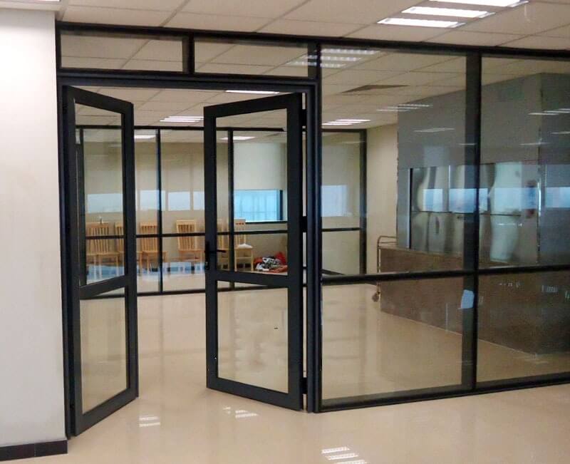 Cửa kính cường lực mở vào văn phòng hiện đại với ánh sáng tự nhiên và nội thất tối giản.