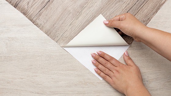 esizc93jp2gqlf1du4k8 Bàn tay dán giấy dán tường vân gỗ, tạo phong cách mới cho sàn nhà.