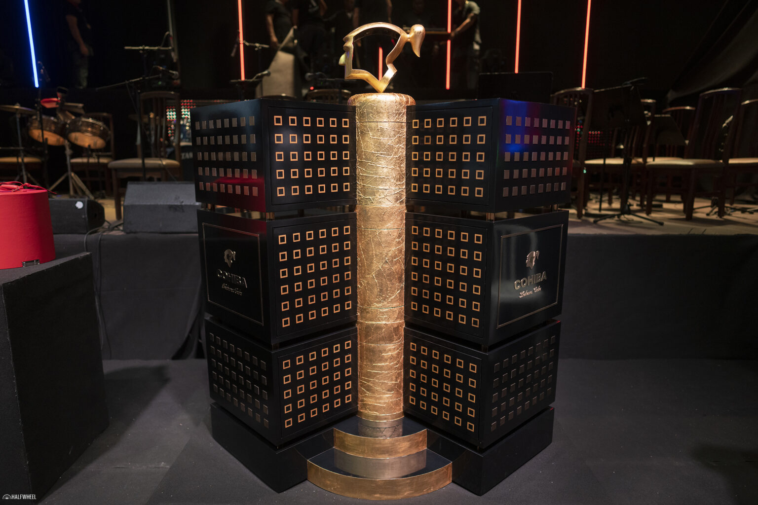 festival-del-habano-xxv-humidor-auction-2025-cohiba-1-1536x1024-1 Tượng trưng bày với thiết kế hiện đại tại sự kiện Cohiba, nổi bật trong không gian tối.