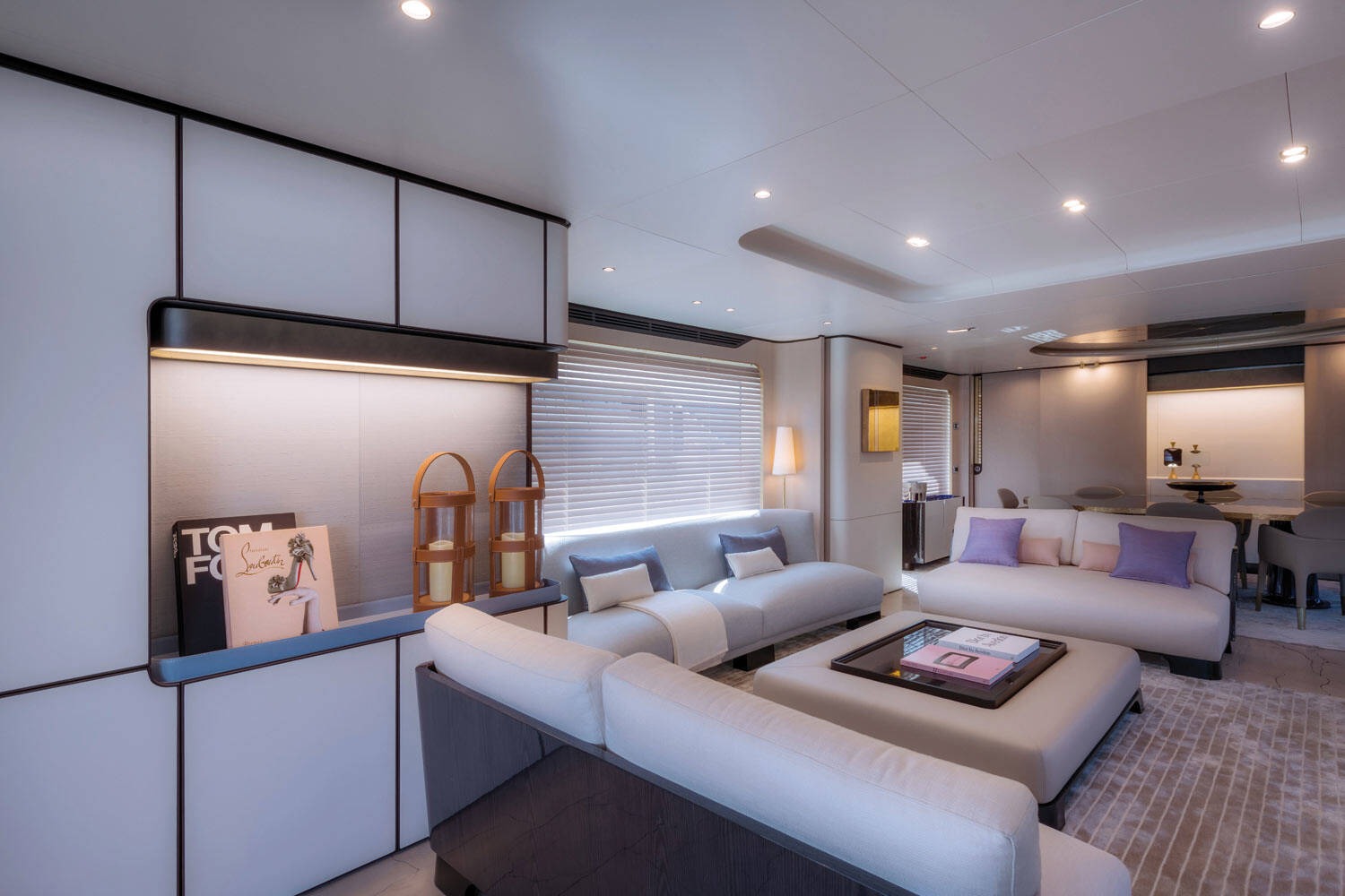 Phòng khách sang trọng với sofa trắng, ánh sáng dịu, trang trí hiện đại và sách nghệ thuật.