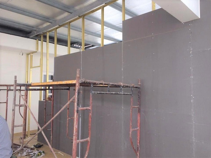 Giàn giáo xây dựng bên cạnh tường thạch cao đang thi công trong tòa nhà.