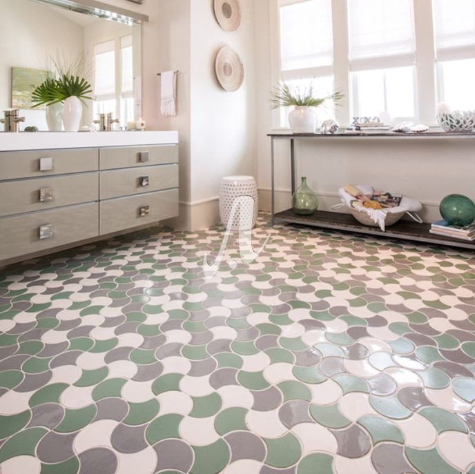 Phòng tắm hiện đại với sàn gạch nghệ thuật màu xanh và xám, tủ trắng và đồ trang trí cây xanh.