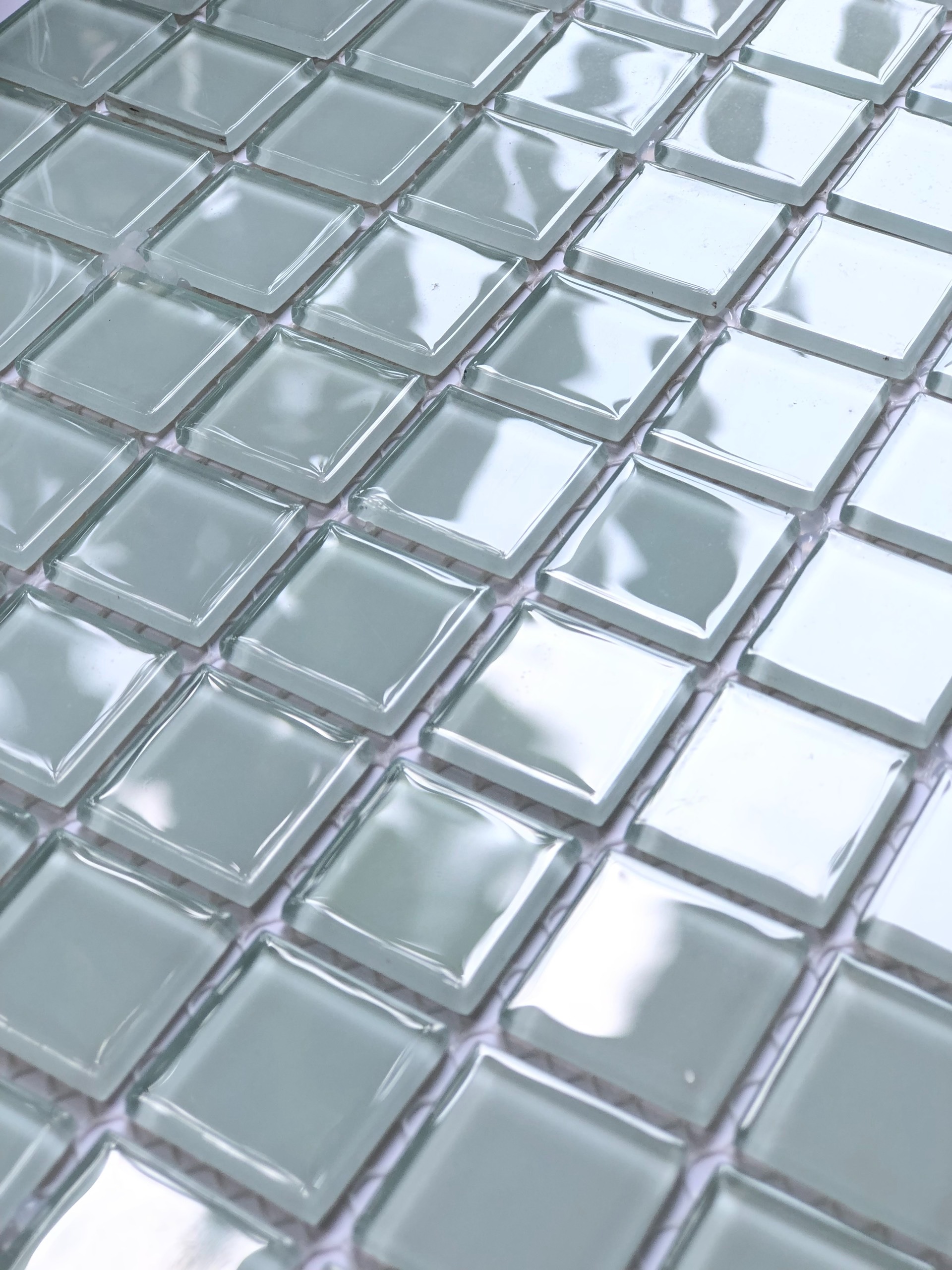 Gạch kính mosaic xanh nhạt, sắp xếp thành ô vuông đều đặn, tạo hiệu ứng ấn tượng và sáng bóng.