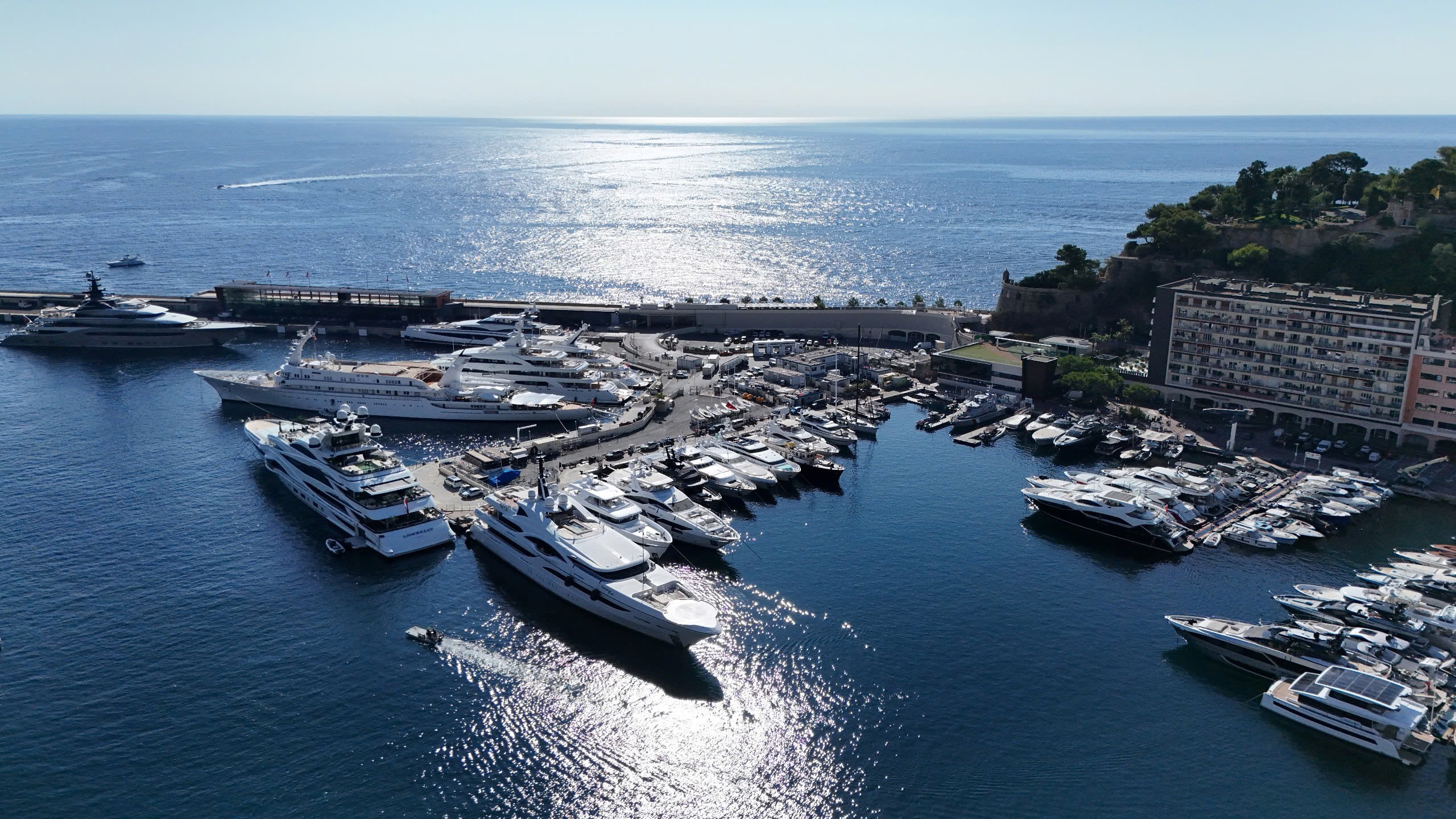 Cảng du thuyền sang trọng Monaco, nước xanh biếc và ánh nắng chiếu sáng.