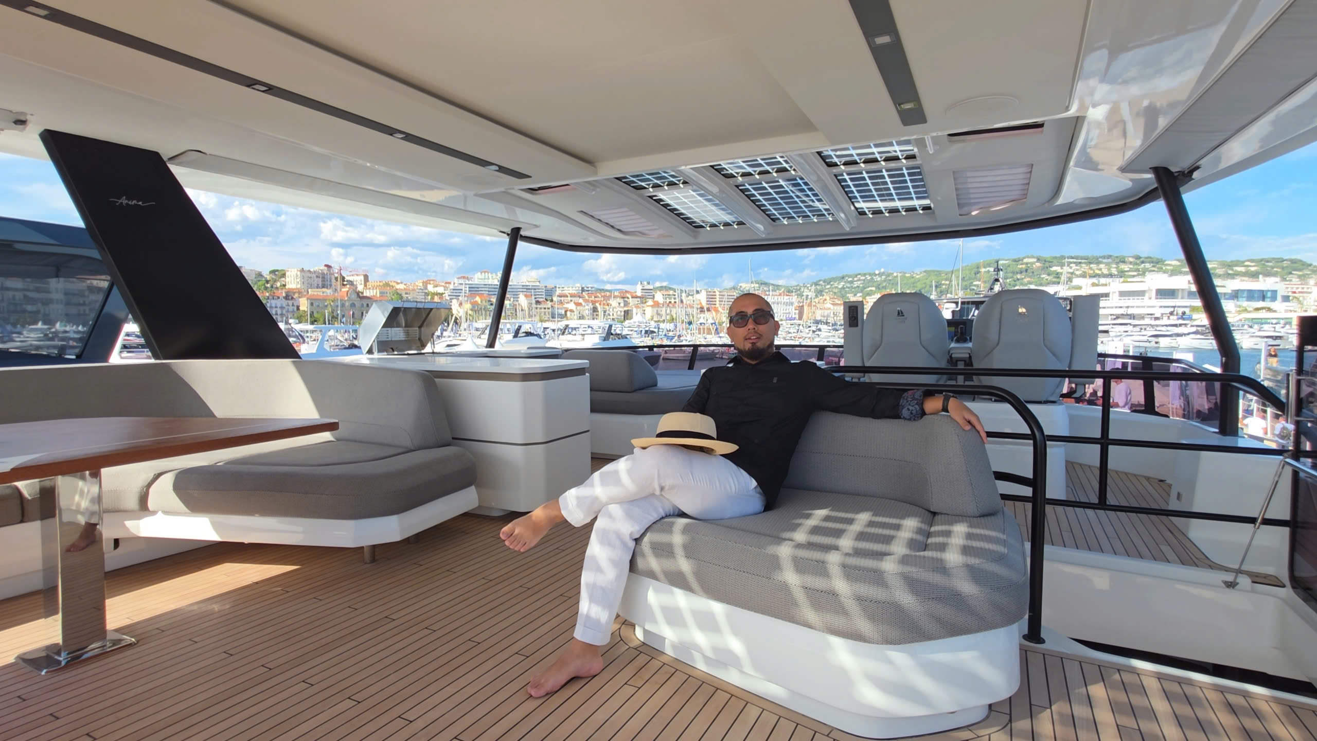 Người đàn ông thư giãn trên du thuyền sang trọng, cảnh biển ở xa trong ngày nắng đẹp.
