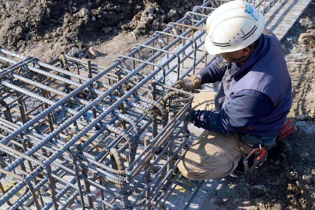 Công nhân xây dựng đang làm việc với khung thép tại công trường. Công việc xây dựng nền móng bê tông.