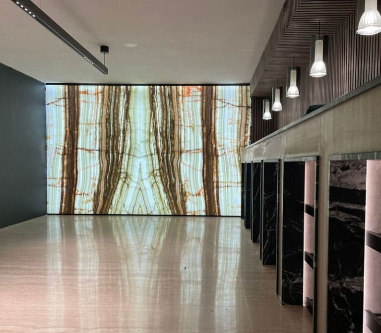 Không gian nội thất với bức tường đá hoa cương lớn, ánh sáng hiện đại và sàn bóng loáng.