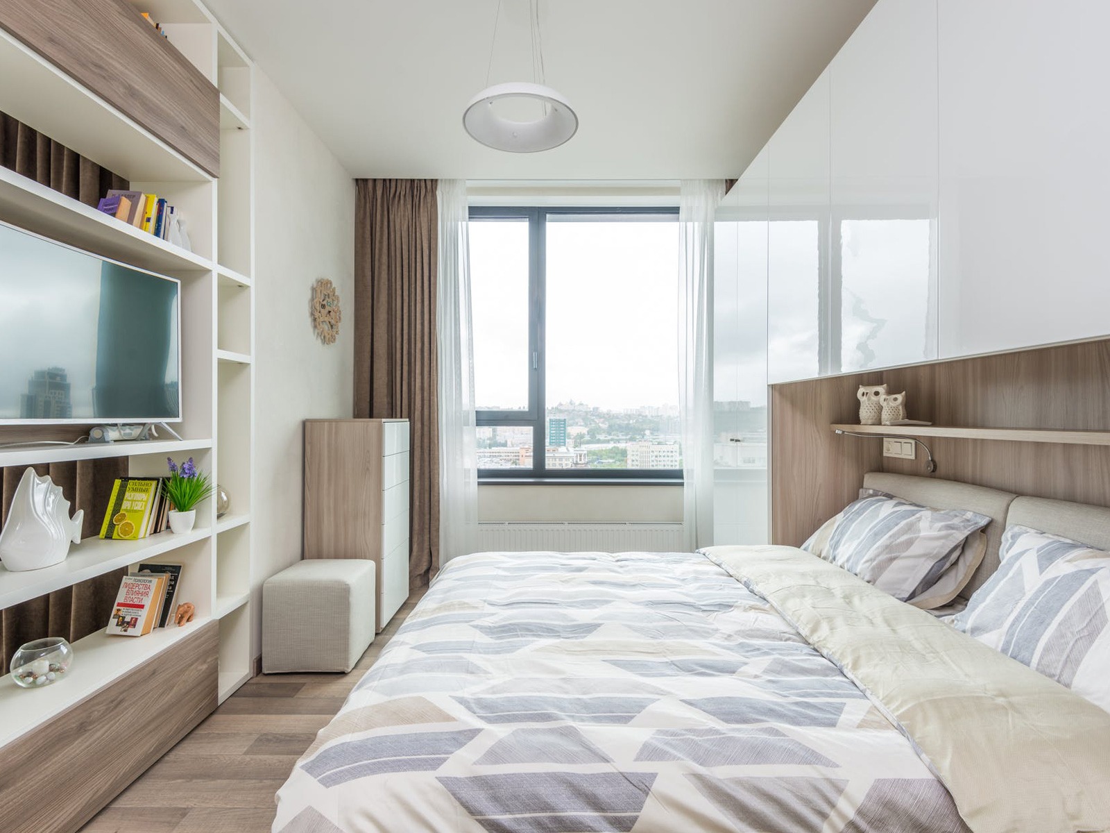 Phòng ngủ hiện đại với giường đôi, cửa sổ lớn và nội thất gỗ sáng.