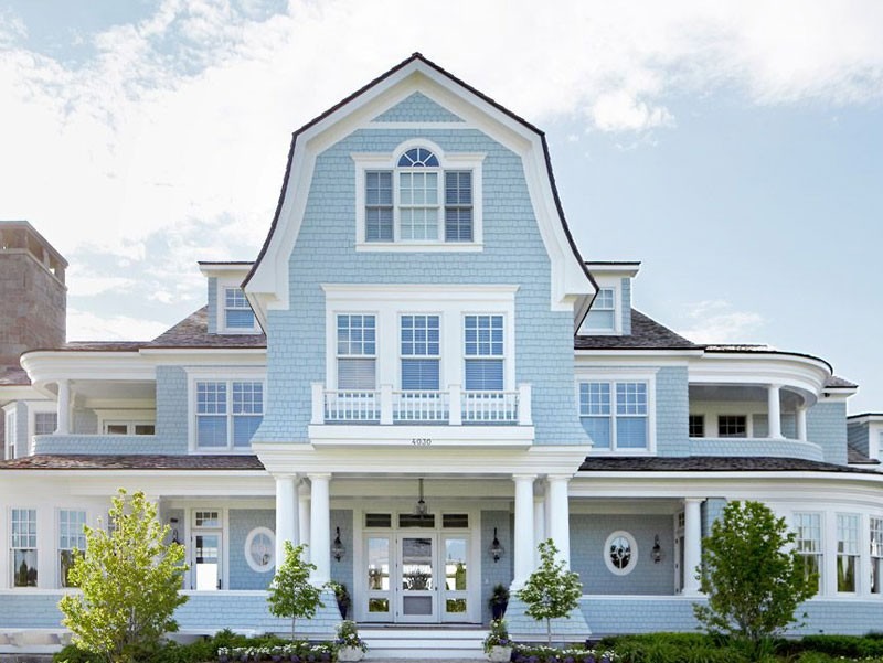 huong-nha-cho-tuoi-giap-tuat Ngôi nhà lớn màu xanh với mái vòm trắng và nhiều cửa sổ, phong cách kiến trúc hiện đại và thanh lịch.