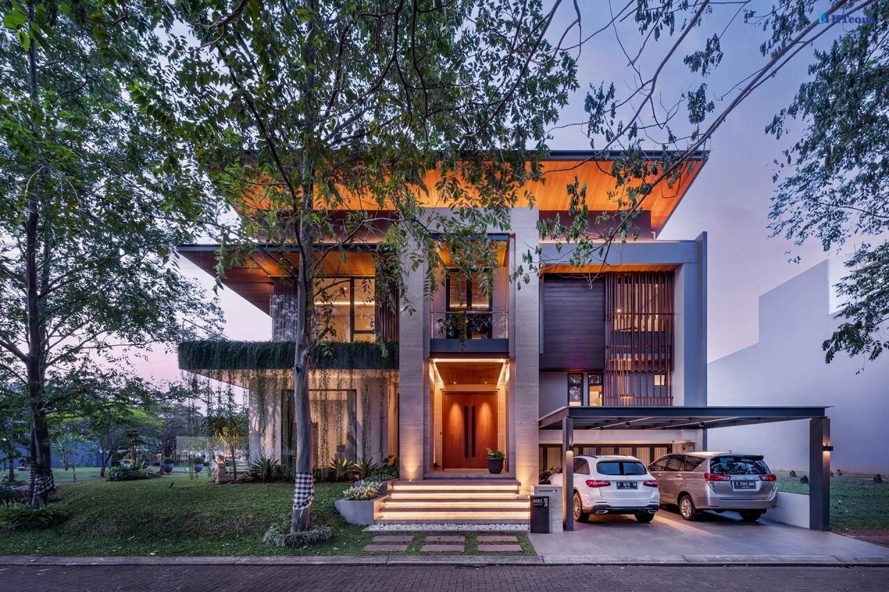 Nhà hiện đại hai tầng với sân vườn, cây xanh, và ô tô đậu trước gara.