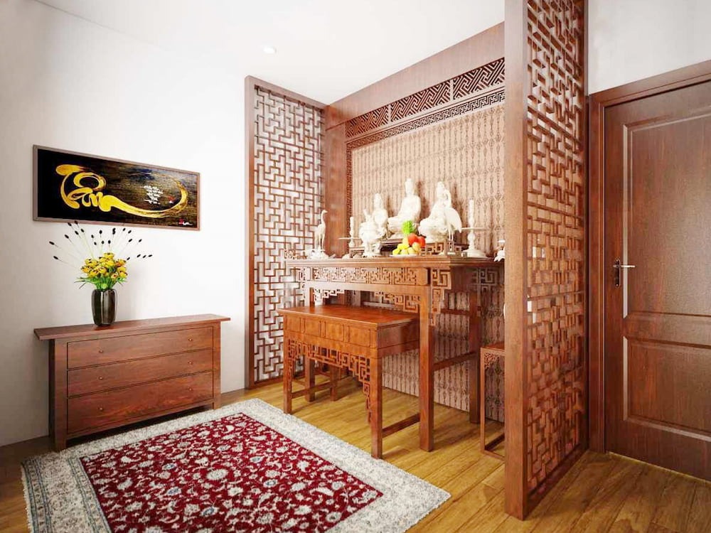 Phòng thờ trang trọng với bàn thờ gỗ, tượng Phật và bình hoa, tạo không gian ấm cúng và thanh tịnh.