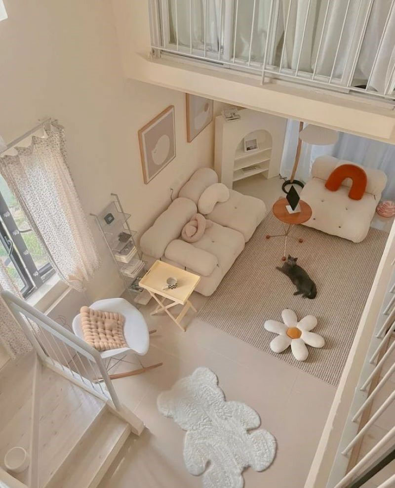 Phòng khách với ghế sofa màu trắng, thảm hoa, mèo thư giãn, không gian sáng tạo và thoải mái.