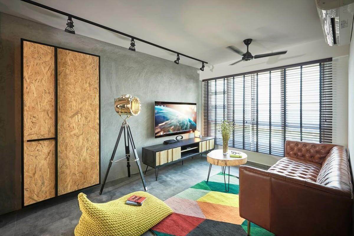 Phòng khách hiện đại với ghế sofa da, đèn tripod, thảm màu sắc và bàn gỗ, ánh sáng từ cửa sổ chớp.