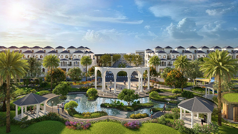 kbt-1 Khu đô thị xanh mát với hồ nước, cây cối, công trình kiến trúc và biệt thự, bầu trời trong xanh.