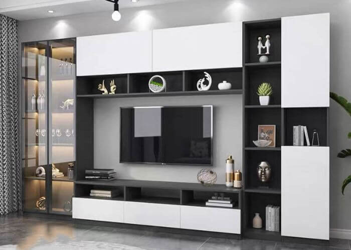 Kệ tivi hiện đại màu trắng đen với đồ trang trí và cây xanh trong phòng khách.