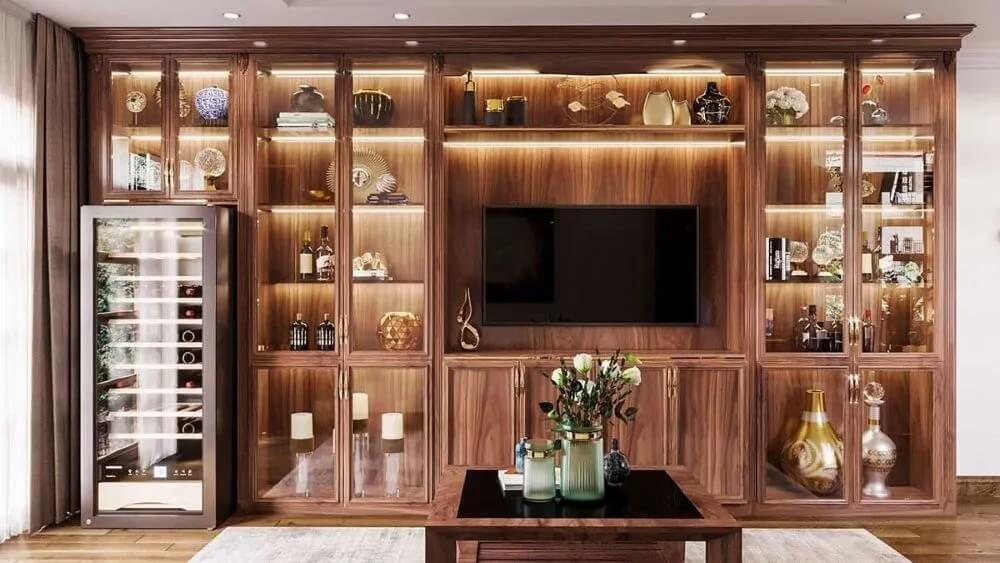 Phòng khách sang trọng với tủ trưng bày gỗ và kệ rượu, trang trí đèn LED và lọ hoa trên bàn.