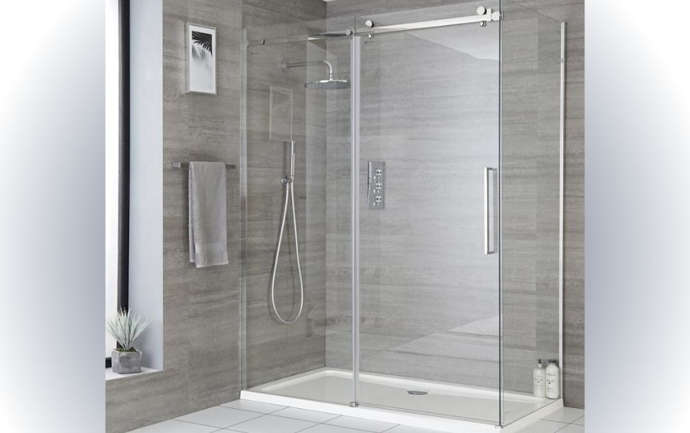 kich-thuoc-bon-tam-dung-lon Phòng tắm hiện đại với cửa kính trượt, vòi sen đứng và nội thất gạch sáng màu, thiết kế thanh lịch.