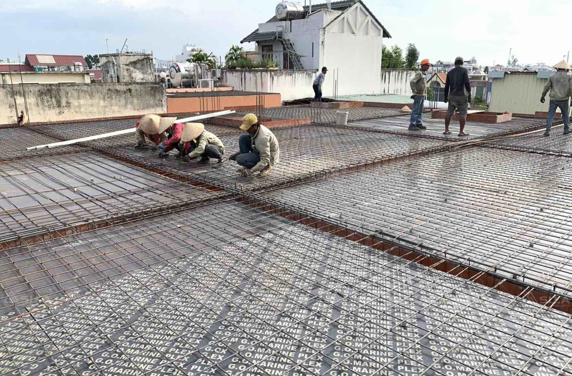 Công nhân xây dựng đang làm việc trên mái bê tông cốt thép.